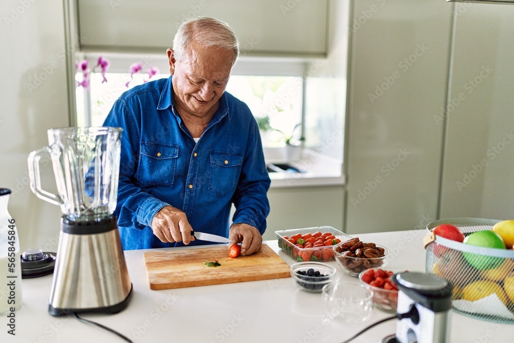 Senior man smiling confident cutting strawberry at kitchen Senior man smiling confident cutting strawberry at kitchen