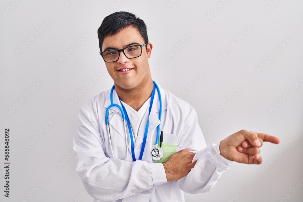 Young hispanic man with down syndrome wearing doctor uniform and stethoscope smiling happy pointing with hand and finger to the side Young hispanic man with down syndrome wearing doctor uniform and stethoscope smiling happy pointing with hand and finger to the side