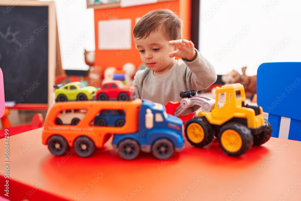 Adorable hispanic boy playing with truck toy at kindergarten Adorable hispanic boy playing with truck toy at kindergarten