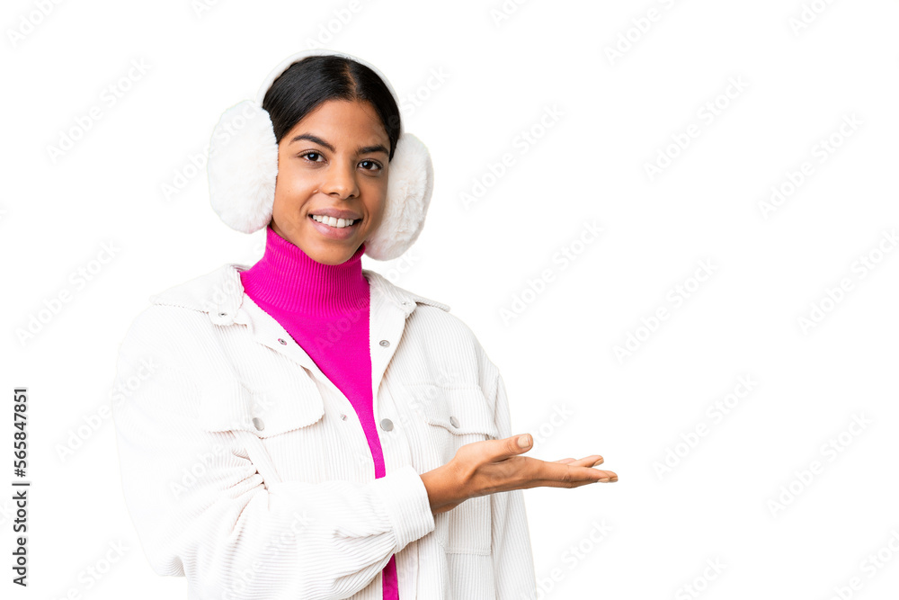 Young African American woman wearing winter muffs over isolated chroma key background presenting an idea while looking smiling towards Young African American woman wearing winter muffs over isolated chroma key background presenting an idea while looking smiling towards