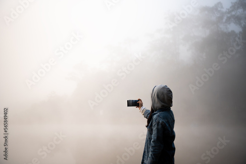 Happy traveler woman taking photo Nature view by smartphone