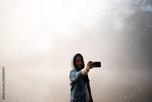 Happy traveler woman taking photo Nature view by smartphone