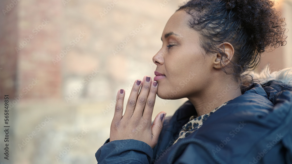African american woman praying with closed eyes at street African american woman praying with closed eyes at street