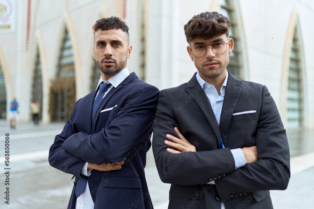 Two hispanic men business workers standing with arms crossed gesture at street Two hispanic men business workers standing with arms crossed gesture at street