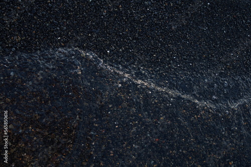 Fragment of water on black gravel
