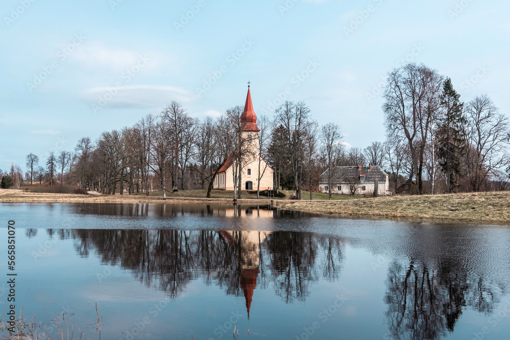 Fototapeta premium Āraiši Evangelical Lutheran Church reflected in a lake at early spring, Latvia.