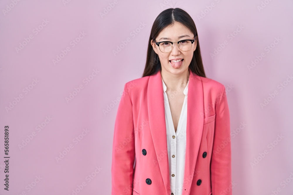 Chinese business young woman wearing glasses sticking tongue out happy with funny expression. emotion concept. Chinese business young woman wearing glasses sticking tongue out happy with funny expression. emotion concept.