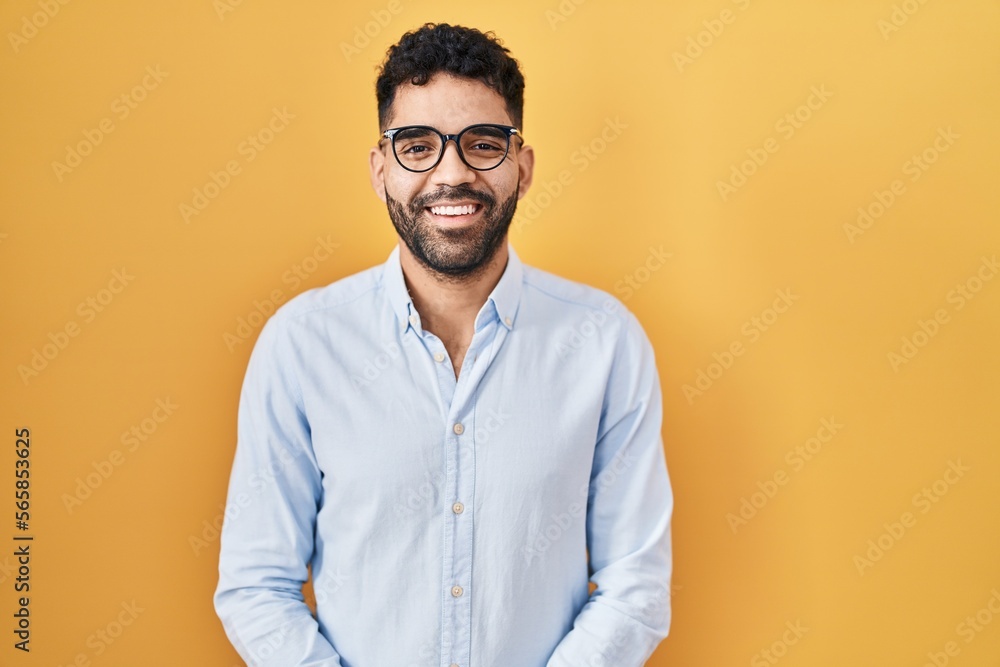 Hispanic man with beard standing over yellow background with a happy and cool smile on face. lucky person. Hispanic man with beard standing over yellow background with a happy and cool smile on face. lucky person.