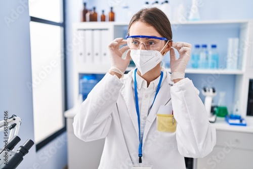 Young caucasian woman scientist wearing medical mask at laboratory