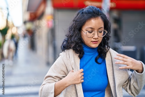 Young chinese woman with relaxed expression standing at street