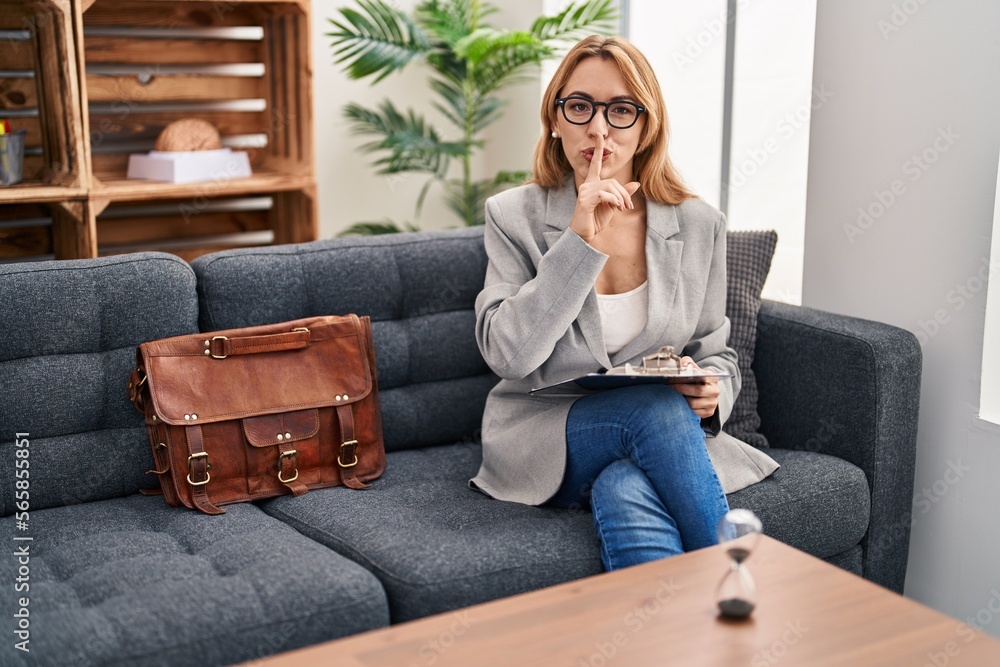 Hispanic woman working at consultation office asking to be quiet with finger on lips. silence and secret concept. Hispanic woman working at consultation office asking to be quiet with finger on lips. silence and secret concept.