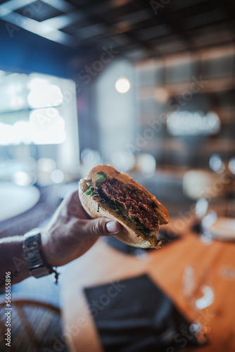 mitad de la hamburguesa en la mano
