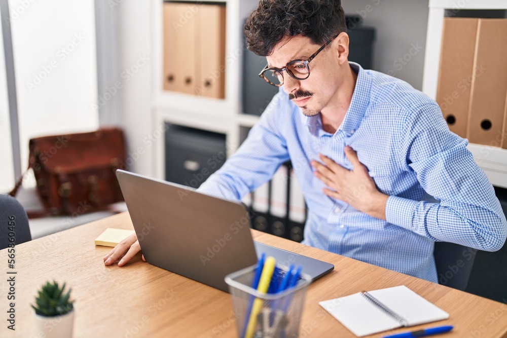 Young caucasian man business worker using laptop suffering chest pain at office Young caucasian man business worker using laptop suffering chest pain at office