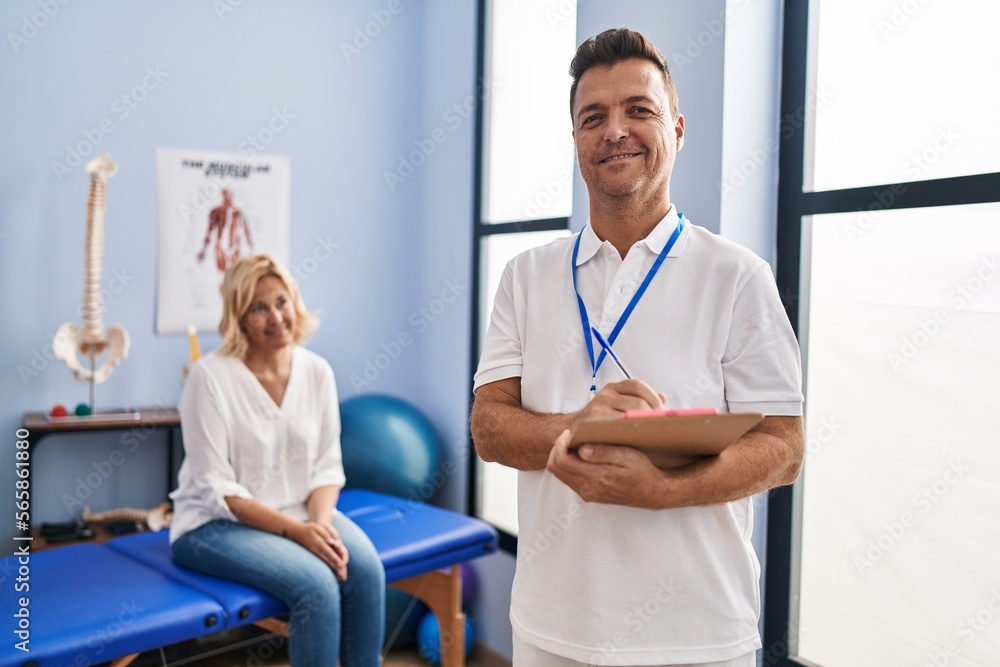 Middle age man and woman physiotherapist and patient having rehab session at physiotherapy clinic Middle age man and woman physiotherapist and patient having rehab session at physiotherapy clinic