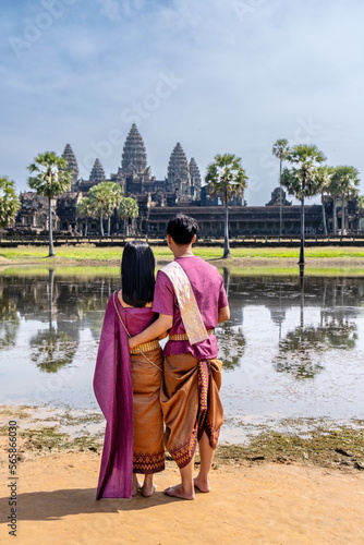 Undefined Cambodian pair dressed in national costume next to Angkor Wat's main facade. Siem Reap