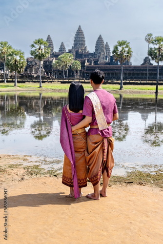 Undefined Cambodian pair dressed in national costume next to Angkor Wat's main facade. Siem Reap