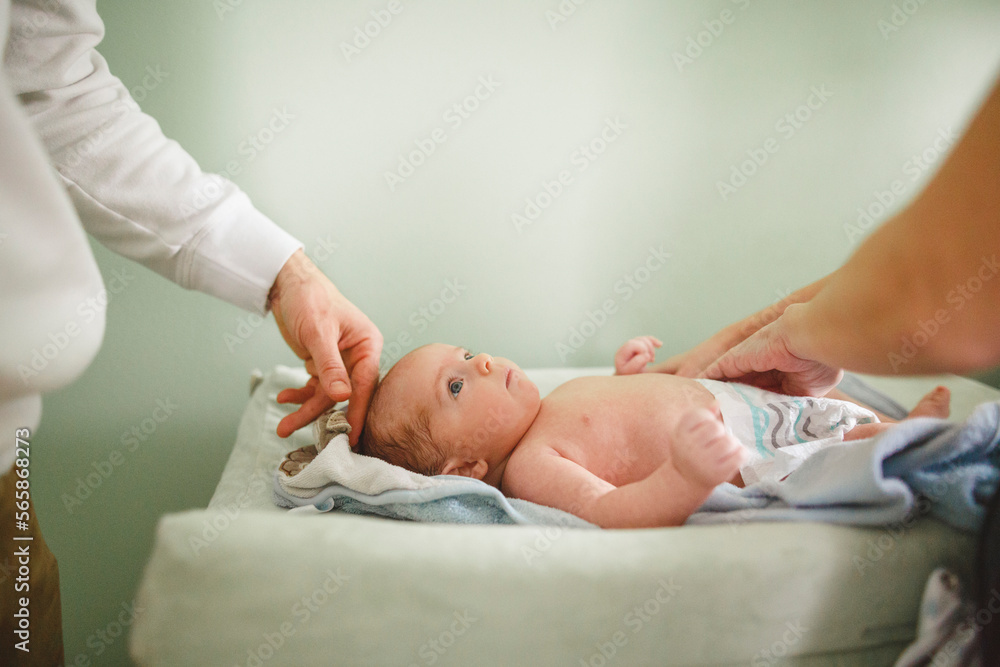 Cropped image of mother changing daughter's diaper at home Cropped image of mother changing daughter's diaper at home