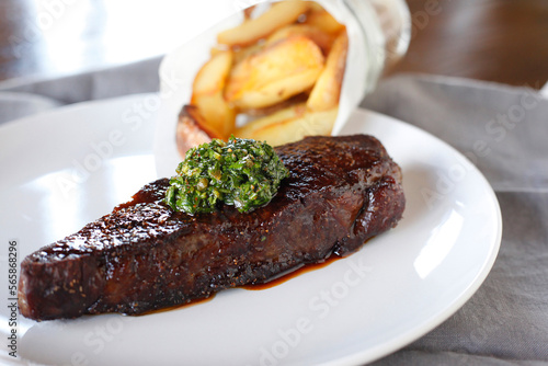 Close-up of steak with French fries served in plate on table photo