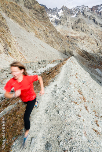 Woman trail running above the Glacier Noir. photo