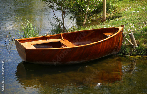 A small wooden row boat is tied to shore. photo