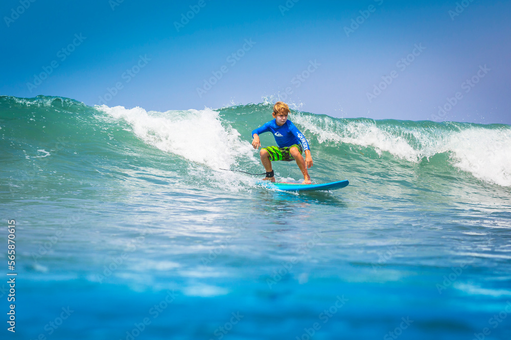 Young surfer, happy young boy in the ocean on surfboard Young surfer, happy young boy in the ocean on surfboard