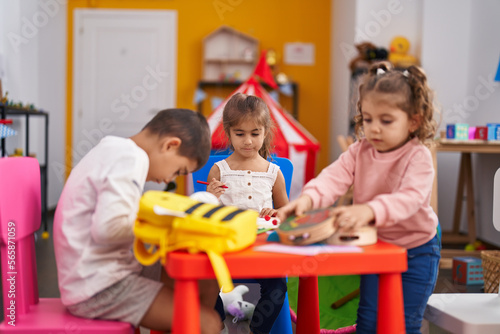 Group of kids preschool students sitting on table drawing on paper at kindergarten
