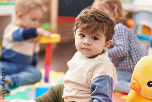 Group of kids playing with toys sitting on floor at kindergarten