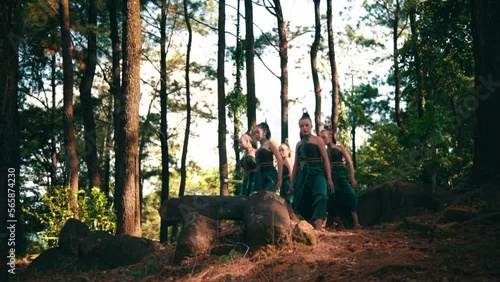 A Group of Indonesian women dancing together in a green dress while performing at the festival inside the village photo