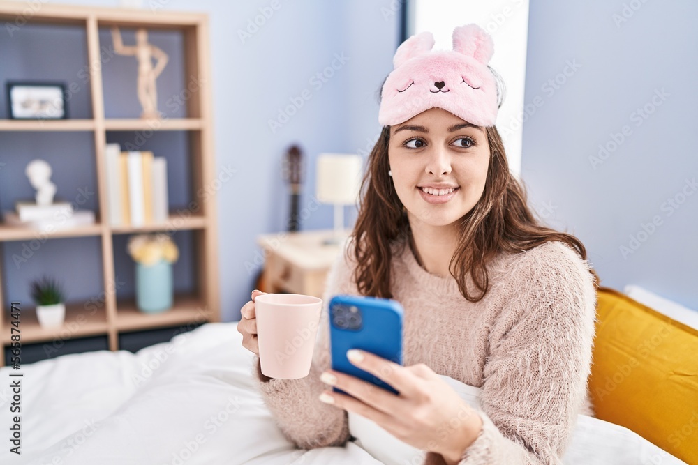 Young beautiful hispanic woman using smartphone drinking coffee at bedroom Young beautiful hispanic woman using smartphone drinking coffee at bedroom