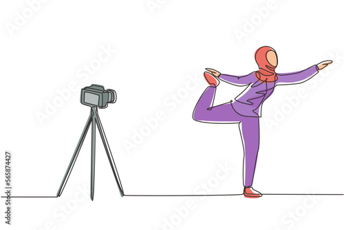 Single continuous line drawing Arab woman blogger in hijab sportswear shoots video on camera doing exercises at home. Fitness vlogger live broadcast of training session. One line draw design vector