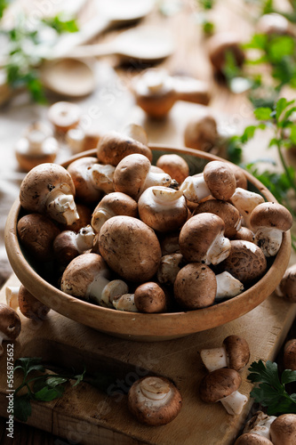 Fresh brown mushrooms in a ceramic rustic bowl, close-up view. Organic brown champignons 