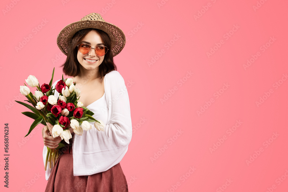 Happy pretty young caucasian woman in casual, hat and glasses with flower bouquet, enjoy birthday Happy pretty young caucasian woman in casual, hat and glasses with flower bouquet, enjoy birthday