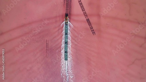 Aerial view of an old train rides on the railway laid in the water through the salt lake. Salt mining in Lake Burlin. Altai. Bursol. photo