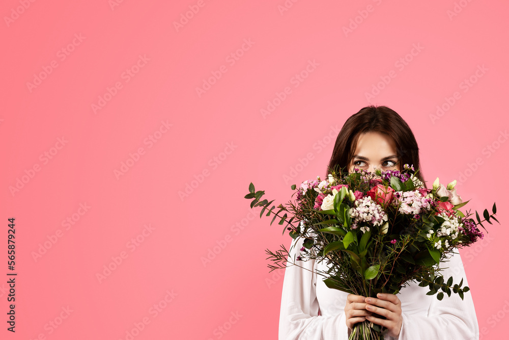 Cheerful young caucasian woman in casual enjoy aroma of bouquet of flowers, rejoices gift Cheerful young caucasian woman in casual enjoy aroma of bouquet of flowers, rejoices gift