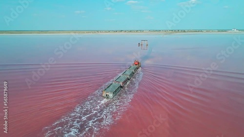 Aerial view of an old train rides on the railway laid in the water through the salt lake. Salt mining in Lake Burlin. Altai. Bursol. photo