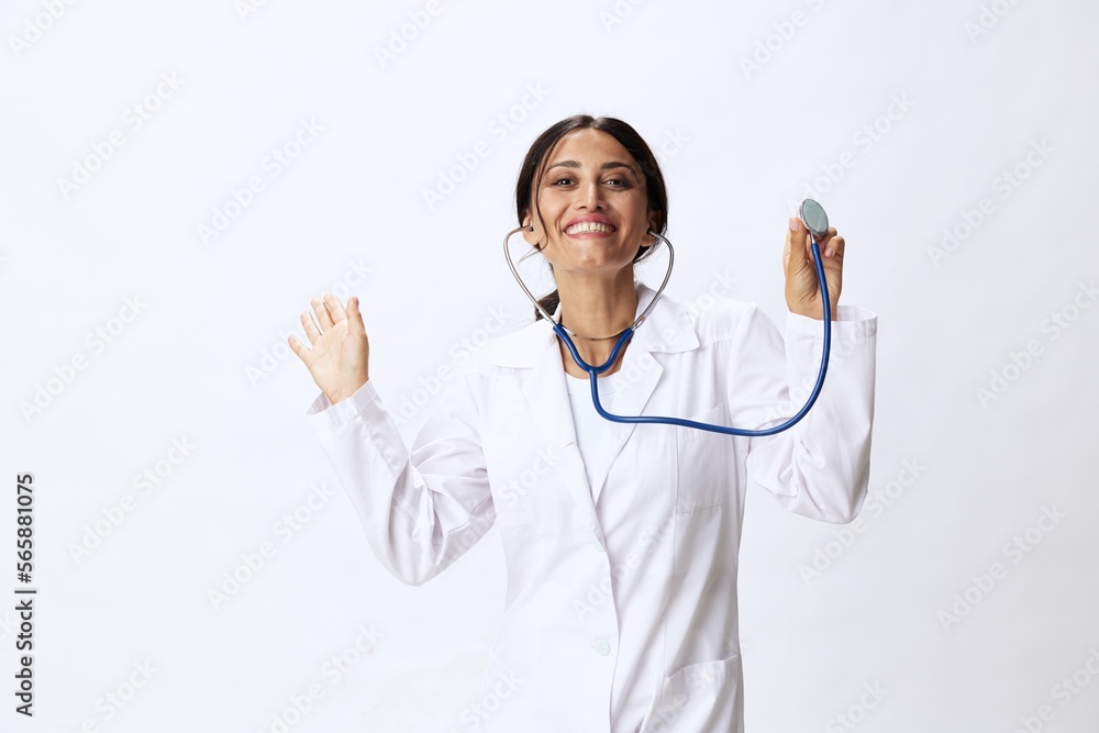 Woman doctor with stethoscope in hand in medical gown on white nurse background, consequences of covid-19, noise in lungs, concept of health and science Woman doctor with stethoscope in hand in medical gown on white nurse background, consequences of covid-19, noise in lungs, concept of health and science