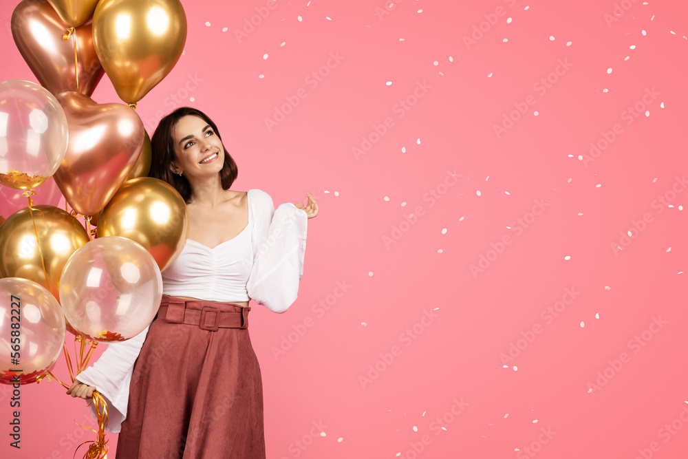 Naklejka premium Happy dreamy young caucasian woman with many inflatable balloons enjoy confetti