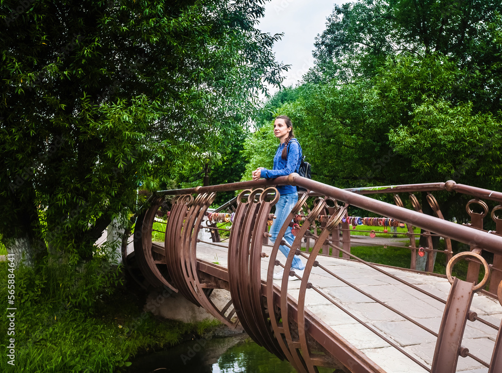 Girl walking on iron bridge in city park Girl walking on iron bridge in city park