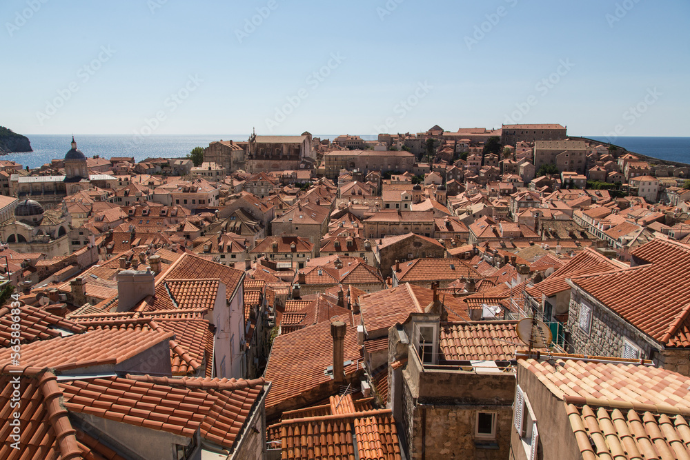 Panorama view from the wall over the terracotta roofs of the ancient stone houses along narrow streets to the blue adriatic sea, Old Town of Dubrovnik, Croatia and UNESCO world heritage