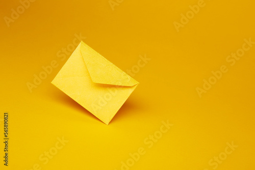 Yellow color paper office envelope for greeting or invitation with copy space isolated on the bright solid fond plain yellow background