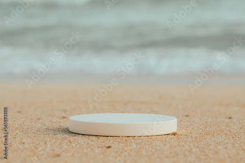 Empty round white platform podium on beach sand background.