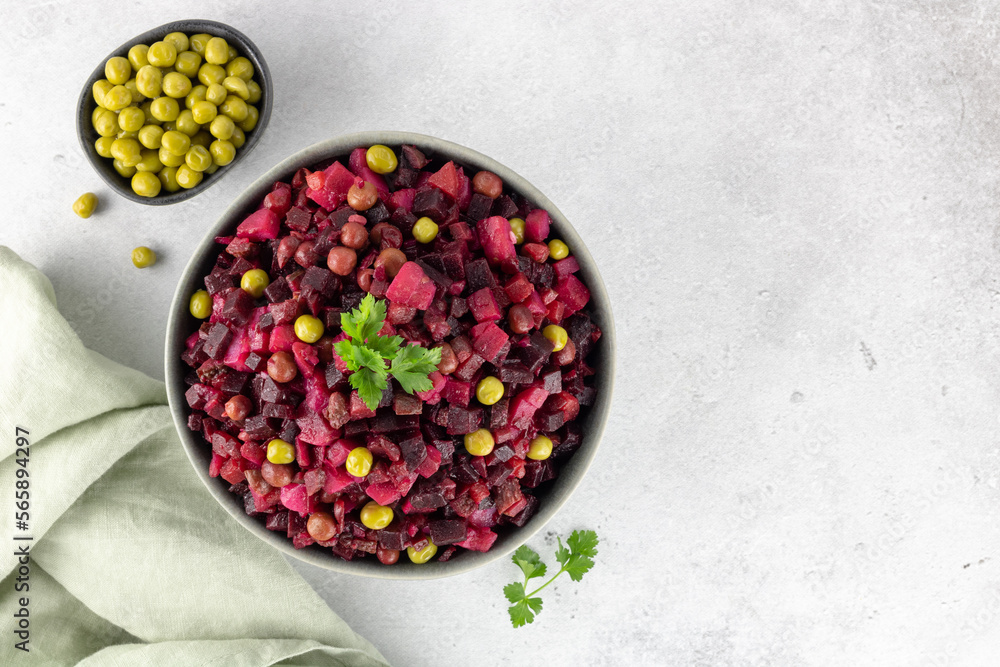 Russian salad. Vinaigrette made from boiled beets, potatoes, carrots, green peas on a gray background. Top view. Copy Space. Beetroot Salad. Russian salad. Vinaigrette made from boiled beets, potatoes, carrots, green peas on a gray background. Top view. Copy Space. Beetroot Salad.
