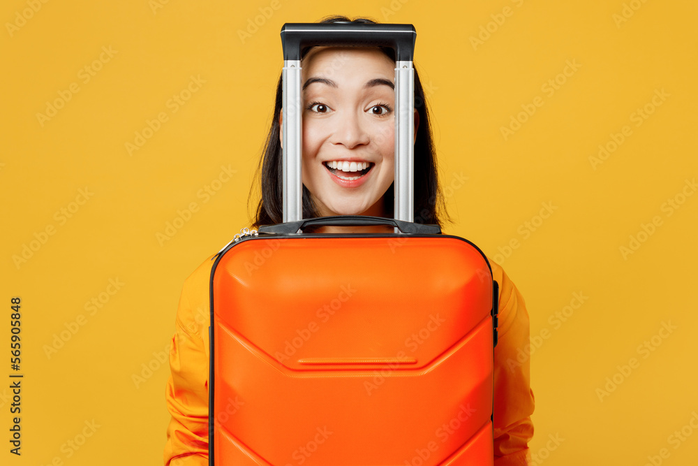 Young cheerful woman wear summer casual clothes look through valise handle isolated on plain yellow background. Tourist travel abroad in free spare time rest getaway. Air flight trip journey concept. Young cheerful woman wear summer casual clothes look through valise handle isolated on plain yellow background. Tourist travel abroad in free spare time rest getaway. Air flight trip journey concept.
