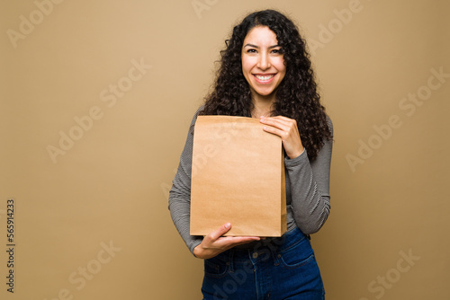 Happy hispanic woman holding a fast food bag photo