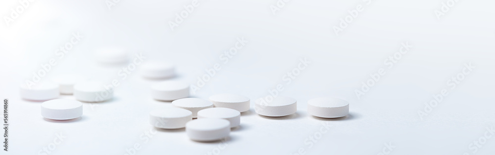 White medical pills placed on a white background White medical pills placed on a white background