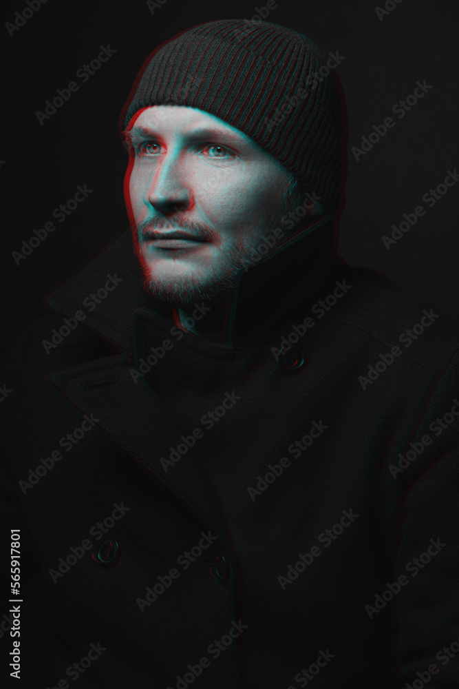 Man with winter hat and black coat studio portrait. Model with beard looking aside the camera with serious look. Red and blue color split effect style. 3D glitch virtual reality effect Man with winter hat and black coat studio portrait. Model with beard looking aside the camera with serious look. Red and blue color split effect style. 3D glitch virtual reality effect