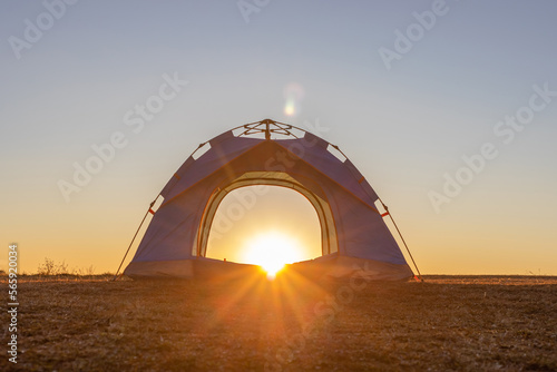 Blue camping tent on top of mountain with amazing sunrise on background. Time spending on fresh air. Travelling concept. © AungMyo