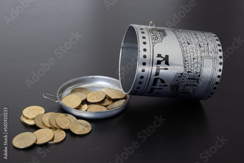 a charity box with coins. Hebrew text [Tzedakah] transltion - Charity. photo