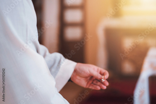 Blurred image of Catholic priest with a small cross in his hands