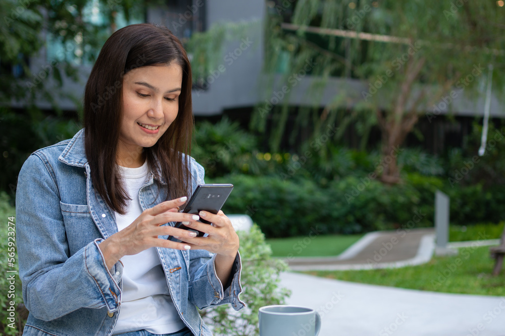 Young asian woman freelancer holding smartphone and reading text message and surf wireless internet on smartphone. Shopping online on a smartphone. Lifestyle women working at home concept. Young asian woman freelancer holding smartphone and reading text message and surf wireless internet on smartphone. Shopping online on a smartphone. Lifestyle women working at home concept.